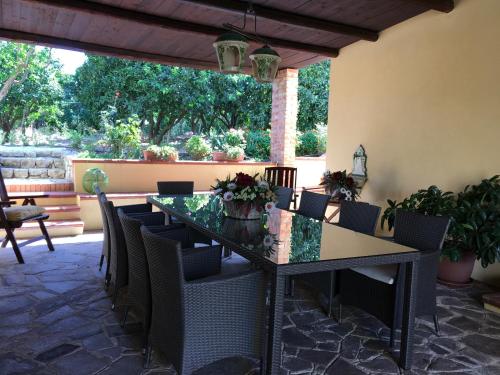 a dining room table and chairs on a patio at Poggio Delle Palme in Campobello di Licata