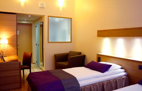 a hotel room with a bed and a chair at Samantta Hotel & Restaurant in Haukipudas