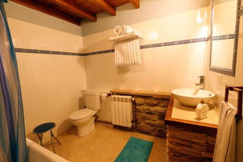 a bathroom with a white toilet and a sink at Casa Gorio in San Mamés
