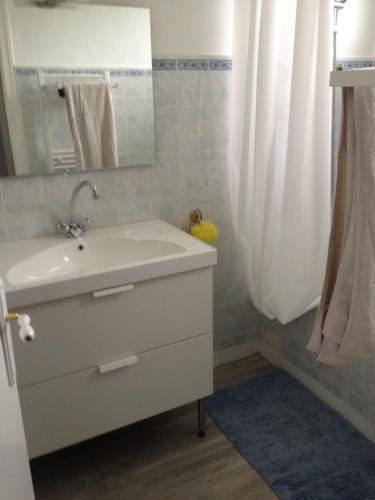 une salle de bain avec un lavabo blanc et une douche dans l'établissement Ma maison, à Créhen