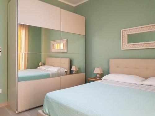 a bedroom with two beds and a mirror at Villa Ada Casa Vacanze in Torre Specchia Ruggeri