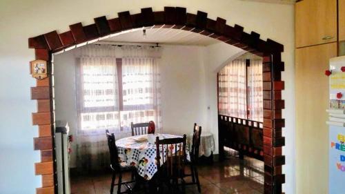 a dining room with a table and a brick archway at Recanto do Sossego in Campos do Jordão