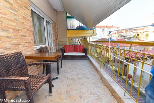 a balcony with chairs and tables on a building at Menios Apartments and Studios in Nea Kalikratia
