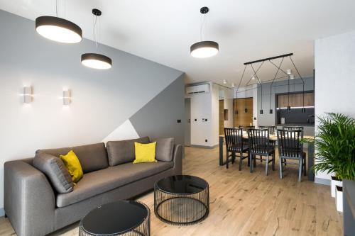 een woonkamer en een keuken met een bank en een tafel bij Exclusive Apartment Solna 1 in Krakau