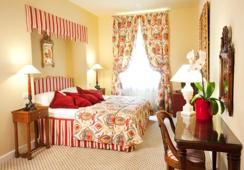 a bedroom with a bed with red pillows and a window at NARUTIS Hotel - Small Luxury Hotels of The World in Vilnius