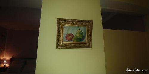 a painting of fruit hanging on a wall at Guest House Nise in Tbilisi City