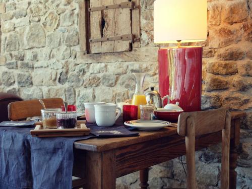 una mesa de madera con una lámpara encima en Le Thé au Jardin, en Saint-Julien-de-Civry