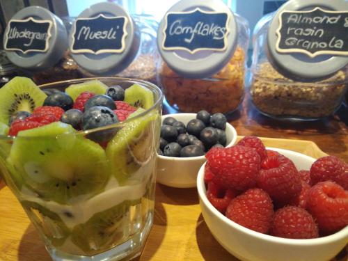 a table topped with bowls of fruit and jars of food at Sleep, Eat, Repeat Bed and Breakfast in Macclesfield