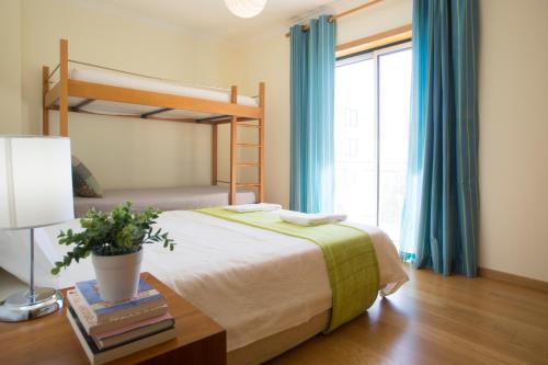 1 dormitorio con litera y mesa con lámpara en Quinta das Rosas - Oceanview Apartment, en Buarcos