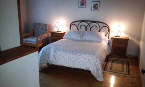 1 dormitorio con 1 cama, 2 sillas y 2 lámparas en Casa La Abuela, en San Mamés