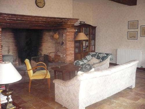 a living room with a couch and a fireplace at Les Convertigues in Montjoire