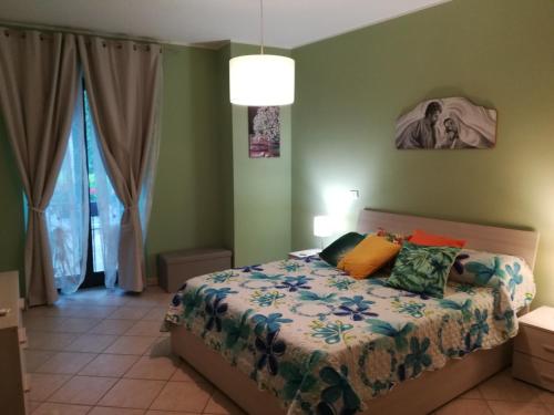 - une chambre dotée d'un lit avec des oreillers colorés dans l'établissement "Profumo di Tiglio", à Bagnoregio