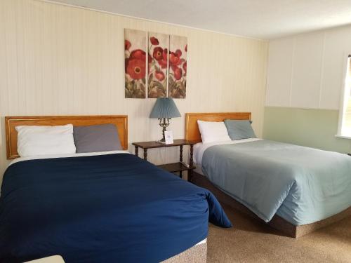 a bedroom with two beds and a painting on the wall at Melsask Motel in Melville