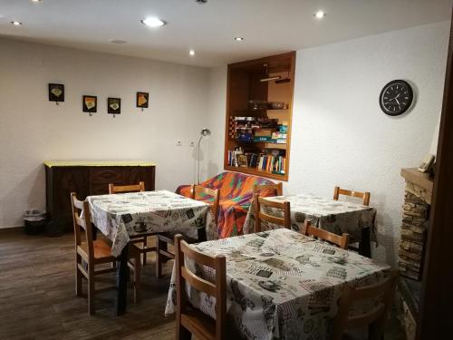 una sala da pranzo con due tavoli, sedie e mensola di La Bodega Del Camino aka Albergue On TheLe a Lorca