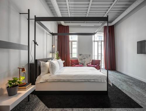 a bedroom with a canopy bed and a chair at BURSA Hotel Kyiv in Kyiv