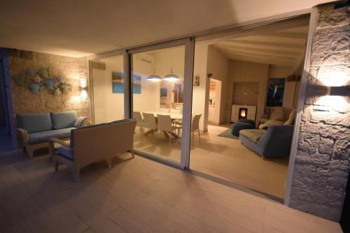 a living room with a couch and a dining room at VILLA BAIRES - CHIA in Domus de Maria