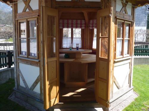a wooden house with windows and a sink in a yard at Pension Wörndl in Fuschl am See