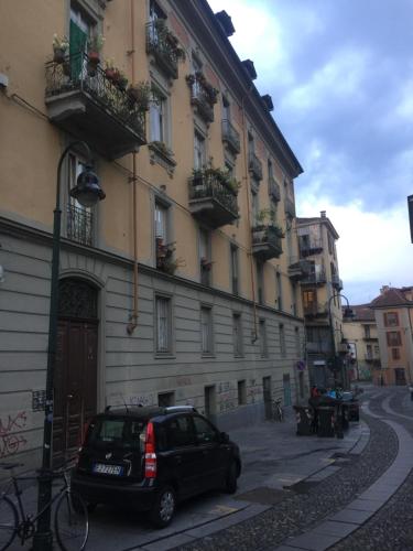 トリノにあるMansarda In Borgo Doraの建物前に駐車する車