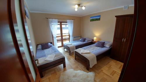 a bedroom with two beds and a window at Apartament Sokola Skała in Falsztyn