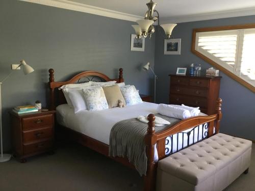 a bedroom with a bed and a chair and a window at Kiama Guesthouse in Kiama