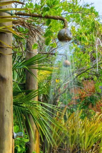 a person is in a fountain in a garden at Hotel Villa Balidendê in Barra Grande