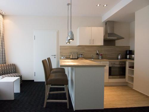 a kitchen with a counter and chairs in a room at Nordsee Domizil Schobüll in Husum