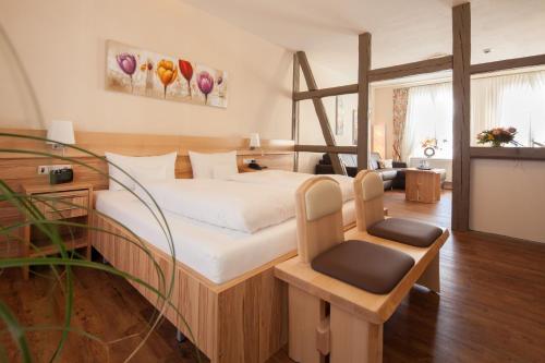 um quarto de hotel com uma cama e uma cadeira em GDA Hotel Schwiecheldthaus em Goslar