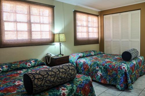 a hotel room with three beds and a phone at Coconut Inn in Palm-Eagle Beach