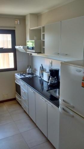 a kitchen with a white refrigerator and a sink at 11 Peyret Rent Aparts in Colón