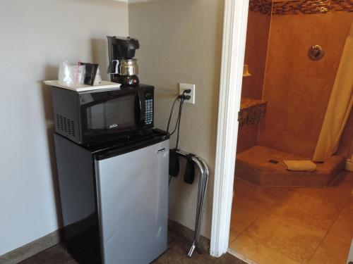 a microwave sitting on top of a refrigerator at Lotus of Lompoc - A Great Hospitality Inn in Lompoc