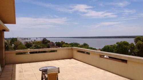 a chair on a balcony with a view of the water at 11 Peyret Rent Aparts in Colón