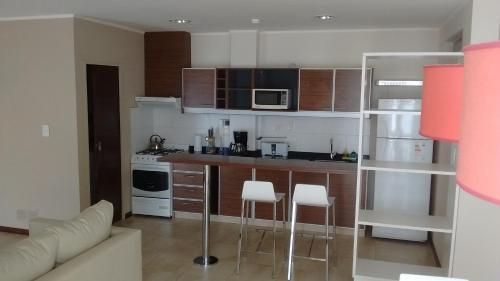 a kitchen with a counter and chairs in a room at 11 Peyret Rent Aparts in Colón