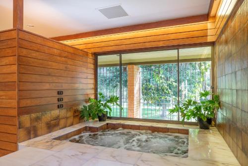 a jacuzzi tub in a room with wooden walls at Spacious Hideaway Retreat, Brookfield, Brisbane in Brisbane