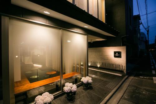 a building with two vases of flowers in a window at Kyoto Kamanza Hotel in Kyoto