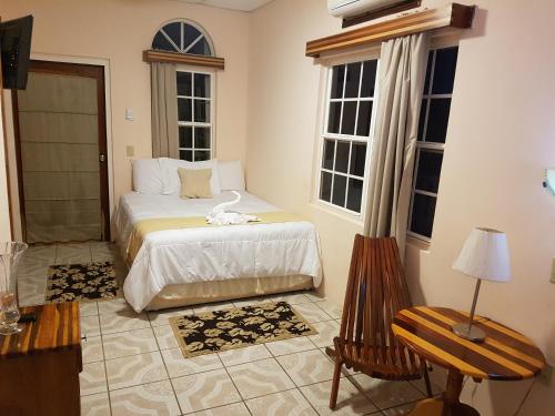 a bedroom with a bed and two windows at Beya Suites in Punta Gorda