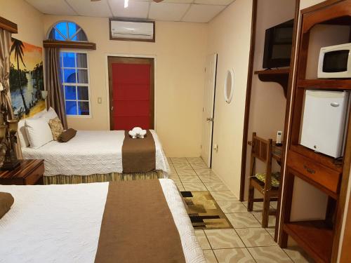 a hotel room with two beds and a tv at Beya Suites in Punta Gorda