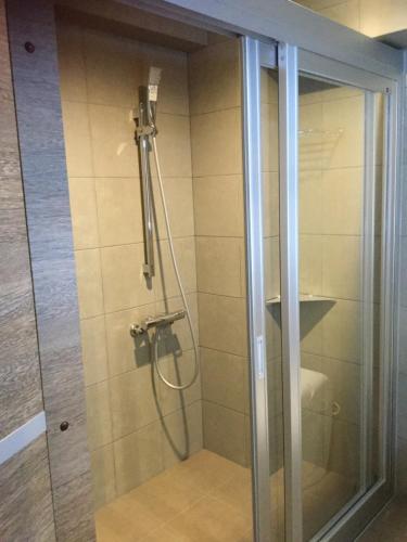 a shower in a bathroom with a glass door at Ryuka Hotel Naha in Naha