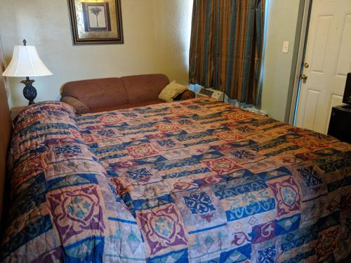 a bed in a hotel room with a quilt on it at San Marina Motel Daytona in Daytona Beach