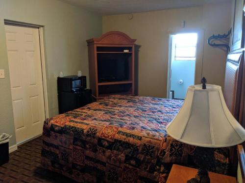 a bedroom with a bed with a lamp on a table at San Marina Motel Daytona in Daytona Beach