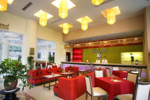 a restaurant with red tables and chairs and a counter at Park View Hotel in Hue