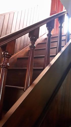 a spiral staircase with wooden railings in a building at Villas Santa Ana-Ricardo in Antigua Guatemala