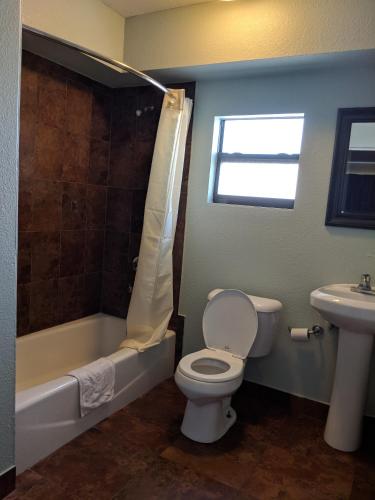 a bathroom with a toilet and a sink at San Marina Motel Daytona in Daytona Beach