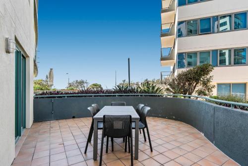 a table and chairs on the balcony of a building at Key Largo Maroochydore in Maroochydore
