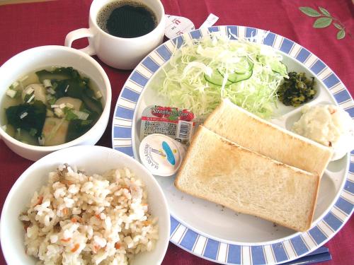 姫路市にあるホテルアストンプラザ姫路のサンドイッチとご飯が載った皿が置かれたテーブル