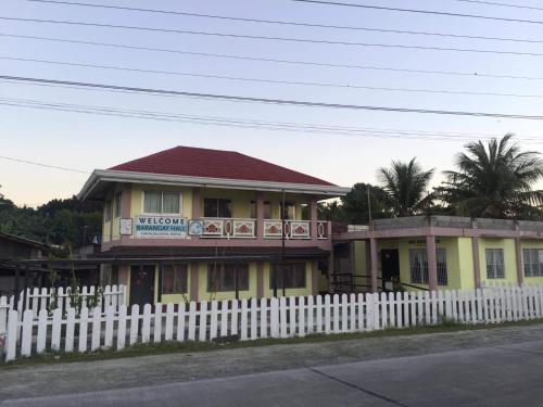a yellow house with a white fence in front of it at Costa Cantagay in Jagna