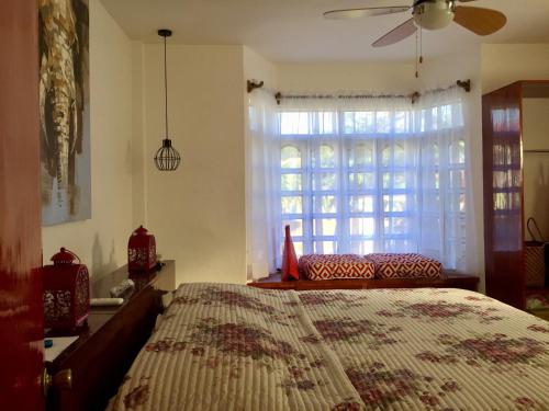 een slaapkamer met een bed en een groot raam bij Costa Cantagay in Jagna