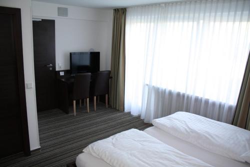 una camera d'albergo con letto, scrivania e finestra di Gasthof Hoppe a Warstein
