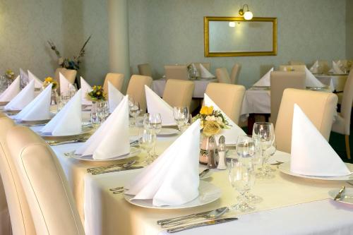 a table with white napkins on it in a restaurant at Hotel Majolika in Modra