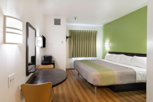 a hotel room with a bed and a table at Motel 6-Hillsboro, TX in Hillsboro