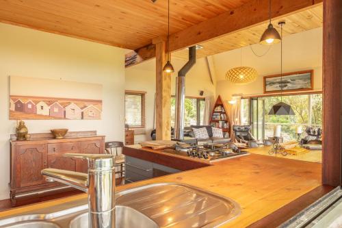 a kitchen with a sink and a wooden ceiling at Absolute Beach front-Tutukaka Harbour in Tutukaka